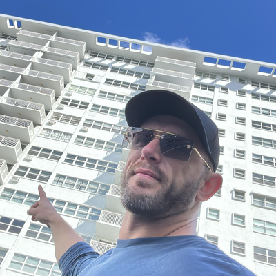 John T. Murray, President of Connected Contracting Corporation, pointing at a high-rise he worked on in South Florida